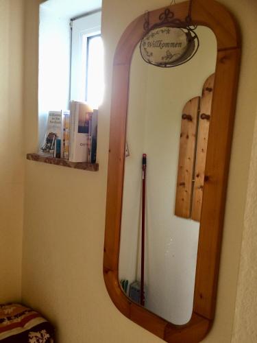 a mirror with a wooden frame on a wall at Hus Nordhauk in Borkum