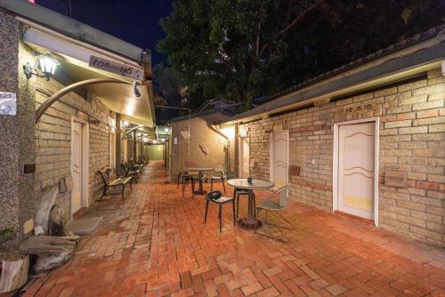 a brick walkway with tables and chairs in a building at 一口井溫泉 One Well Hot Spring in Jiaoxi