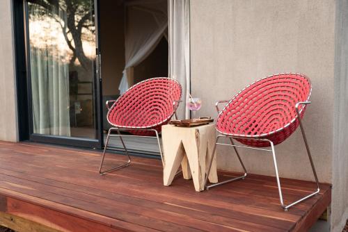two chairs sitting on a deck with a table at Moya Safari Villa in Hoedspruit