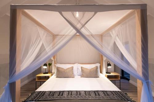 a bedroom with a canopy bed with pillows at Moya Safari Villa in Hoedspruit