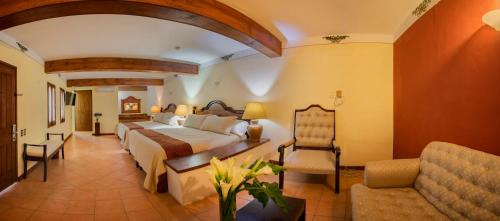 Habitación de hotel con cama y silla en Hotel Casa Barrocco Oaxaca, en Oaxaca City