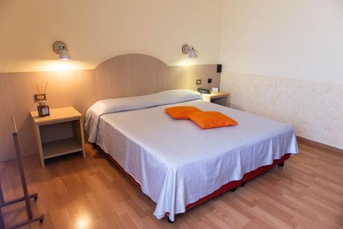 a bedroom with a bed with an orange towel on it at Hotel Europa in Chivasso