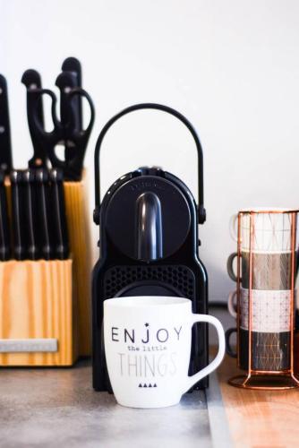 une tasse de café sur une table à côté d'une valise dans l'établissement Le superbe des Dominicains, à Nancy