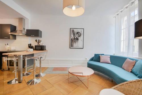 a living room with a blue couch and a table at Le superbe des Dominicains in Nancy