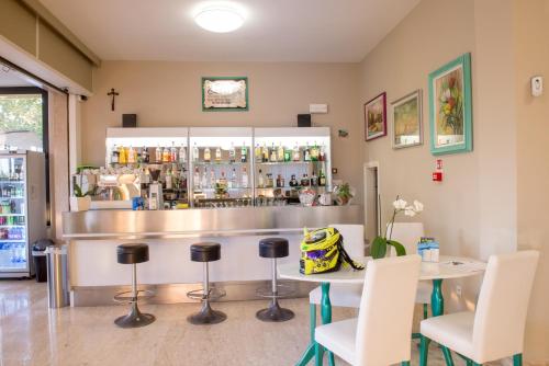 a bar in a restaurant with a table and chairs at Hotel Maioli in Misano Adriatico