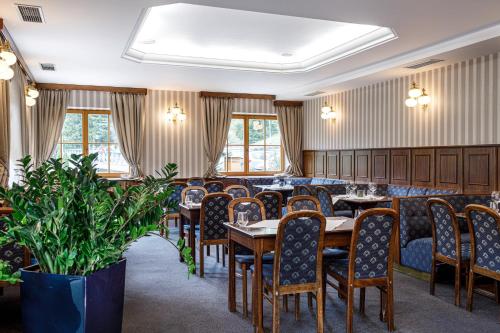 a dining room with tables and chairs and windows at Hotel Zátiší in Špindlerův Mlýn