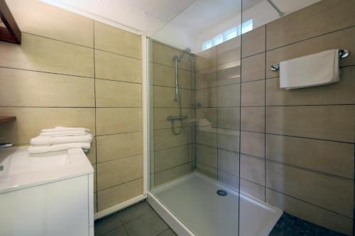 a bathroom with a shower with a glass door at Résidence Lago Verde in Porto-Vecchio