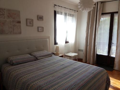 - une chambre avec un lit et une couette à rayures dans l'établissement Le Balcon d'Azur, à Drap