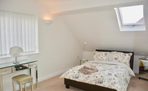 a bedroom with a bed and a desk and windows at glastonbury town garden house in Glastonbury