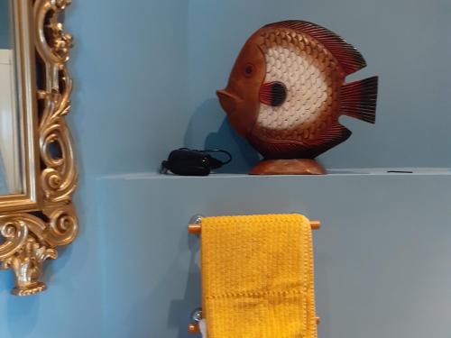 a towel rack with a fish head on it next to a mirror at B&B La Fenice sul Lago in Villongo SantʼAlessandro
