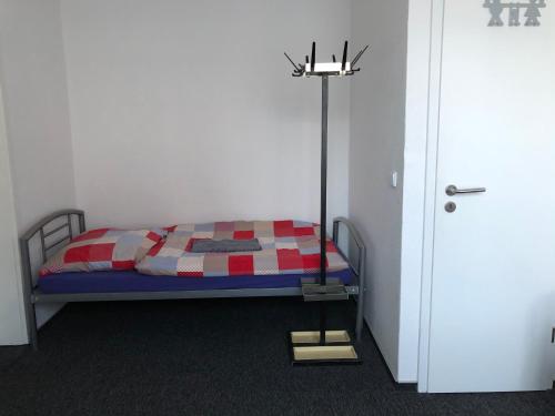 a bedroom with a bed with a red and white quilt at Rana's Zimmervermittlung in Bremen