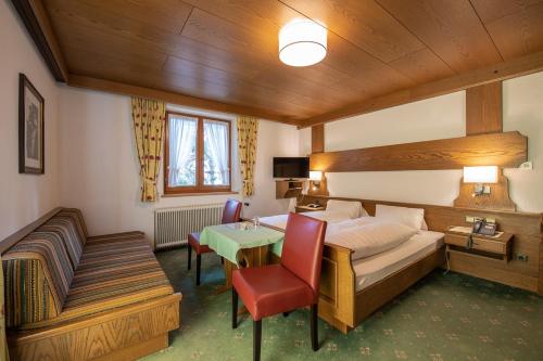 a hotel room with a bed and a table at Haus Gamberg in Sankt Anton am Arlberg