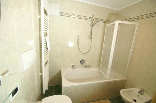 a bathroom with a tub and a toilet and a sink at Appartamenti Residence Pars in Badia