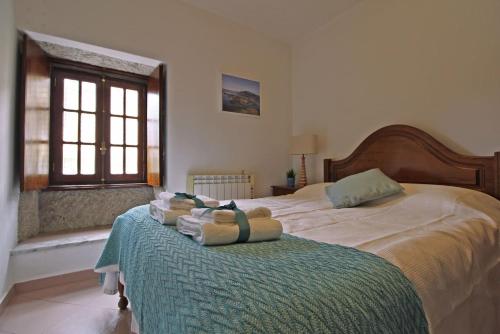 a bedroom with two beds with towels on the bed at Casa do Avô Zé in Caminha