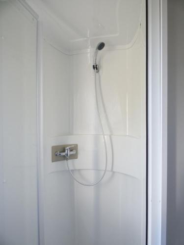 a shower with a shower head in a bathroom at Camping les charmettes- in Les Mathes