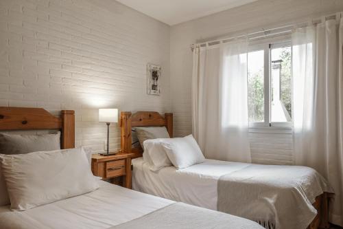 a bedroom with two beds and a window at Valeria House Rental Suites in Valeria del Mar