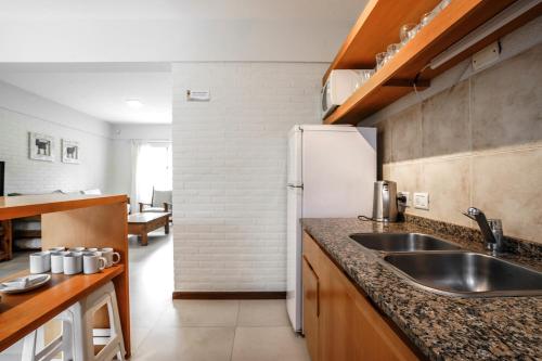 a kitchen with a sink and a refrigerator at Valeria House Rental Suites in Valeria del Mar