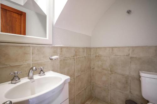 a bathroom with a sink and a toilet at Valeria House Rental Suites in Valeria del Mar