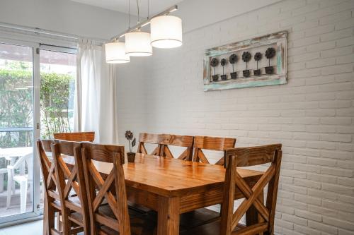 a dining room with a wooden table and chairs at Valeria House Rental Suites in Valeria del Mar