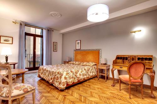 een slaapkamer met een bed en een tafel en stoelen bij San Marco Superior Apartments in Venetië