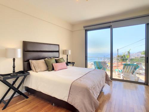 a bedroom with a bed with a view of the ocean at Villa Moniz by LovelyStay in Funchal