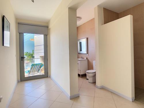a bathroom with a toilet and a sliding glass door at Villa Moniz by LovelyStay in Funchal