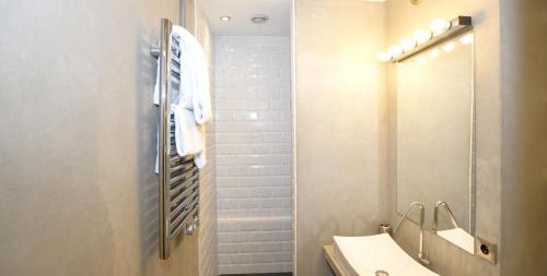 a bathroom with a sink and a shower with a mirror at Appart' Herbouville in Lyon