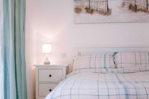 1 dormitorio con cama y mesita de noche con lámpara en Sandville Chalet Portnoo en Portnoo