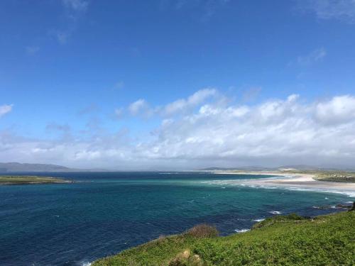 a view of the ocean from a hill with a beach at Sandville Chalet Portnoo in Portnoo