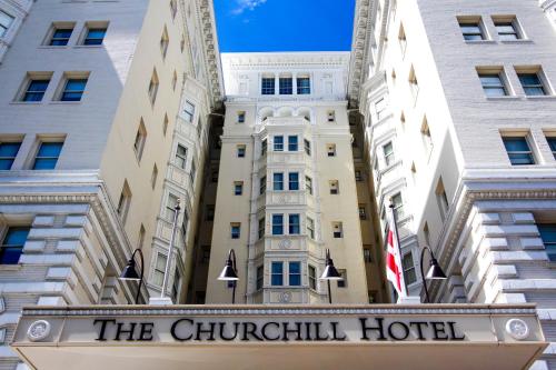 a large building with a sign on the side of it at The Churchill Hotel Near Embassy Row in Washington, D.C.