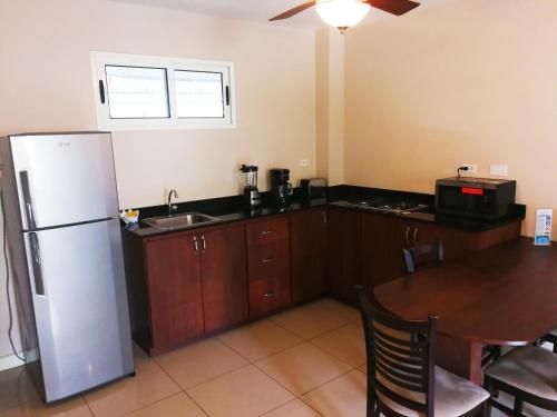 a kitchen with a white refrigerator and a table at Agua Clara Eco Suites in Oranjestad