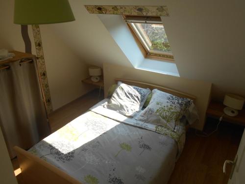 a bedroom with a bed and a window in a attic at Gîte de la Cuve in Huisnes-sur-Mer