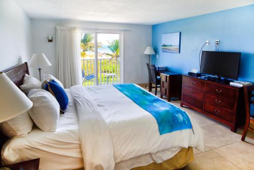 1 dormitorio con 1 cama grande y TV. en Prestige Hotel Vero Beach, en Vero Beach