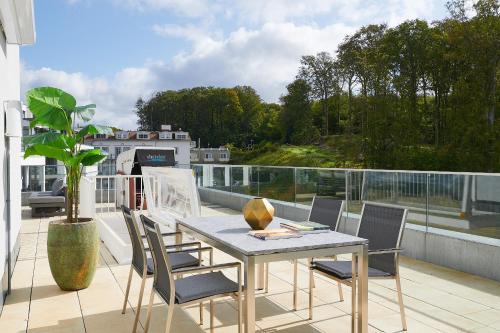 a balcony with a table and chairs on a roof at FIRST im FIRST Sellin, Penthouse Meerselig mit Ostseeblick und Dachterrasse in Ostseebad Sellin