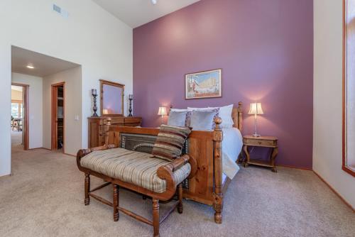 a bedroom with a bed and a chair and purple walls at Snowcreek V 756 in Mammoth Lakes
