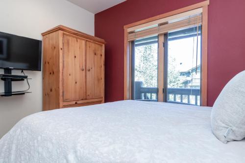 a bedroom with a bed and a television and a window at Snowcreek V 756 in Mammoth Lakes
