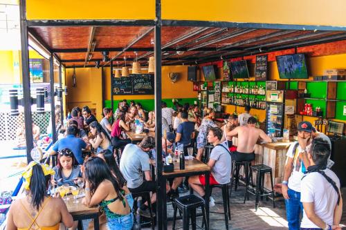 una multitud de personas sentadas en mesas en un restaurante en Wild Rover Huacachina, en Ica