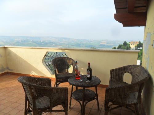 a table and chairs with bottles of wine on a balcony at LA VILLA IN CAMPAGNA in Citta' Sant'Angelo