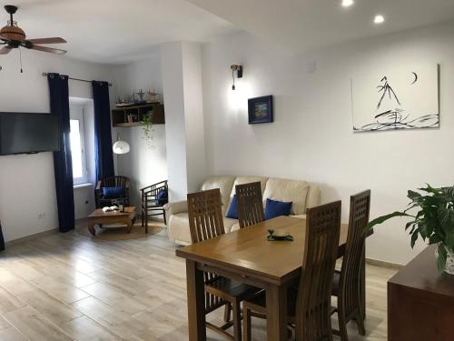 Una sala de estar con una mesa y sillas y un sofá. en Cal Morrudet, en L'Ametlla de Mar