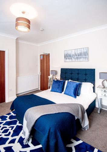 a bedroom with a blue and white bed with blue pillows at MARS Hotel Seaview Blackpool in Blackpool