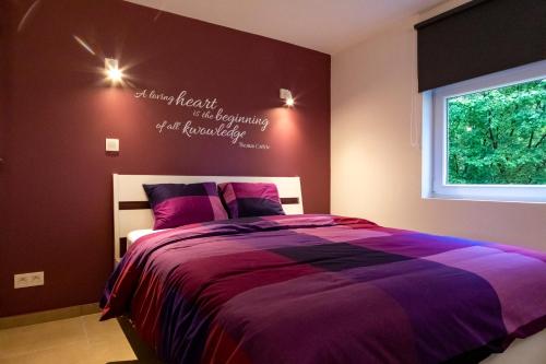a bedroom with a bed with a sign on the wall at Côté terrasse in Malmedy