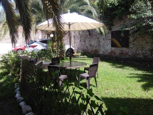 einen Tisch und Stühle unter einem Regenschirm im Hof in der Unterkunft Hostal Del Centro Talca in Talca