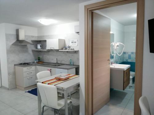 a kitchen with a table and a sink and a counter at Monolocale Tirreno studio seafront in Formia