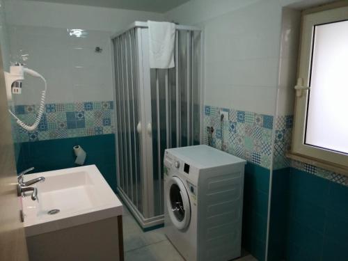 a bathroom with a washing machine and a sink at Monolocale Tirreno studio seafront in Formia