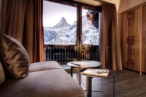 a room with a window with a view of a mountain at The Christiania Mountain Spa Resort in Zermatt
