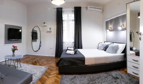 Un dormitorio con una cama grande y un espejo. en Natalie's Place, en Belgrado