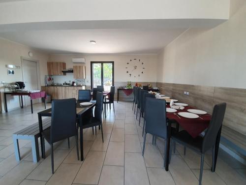 a dining room with tables and chairs and a kitchen at I Colori dell'Etna in San Giovanni la Punta