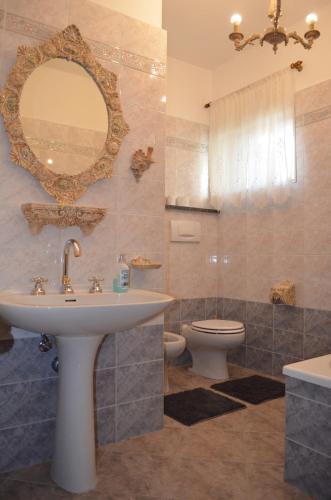 łazienka z umywalką, toaletą i lustrem w obiekcie la casa di sotto w mieście Alpignano