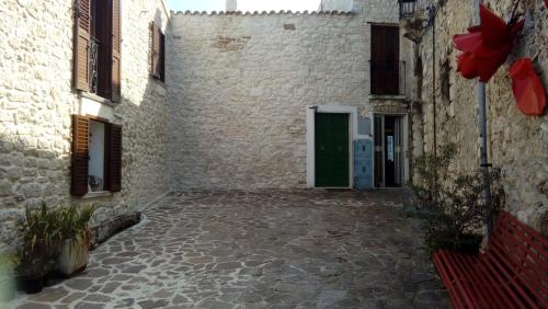 an alley with a green door in a stone building at La maison de Martine in Bolognano