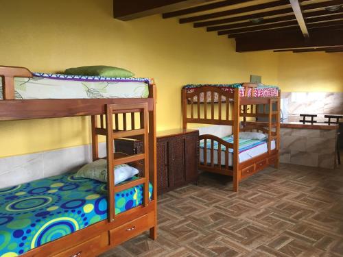 a room with three bunk beds in a room at Mirador Finca Morrogacho in Manizales